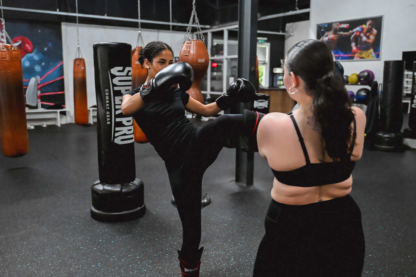 Vrouwen trainen trappen op de bokszak tijdens de dames kickboksles bij BOKS Zoetermeer