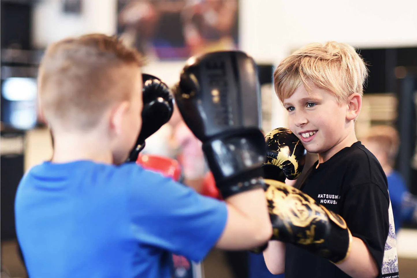 Kind oefent stoottechnieken op de handschoenen bij BOKS Zoetermeer