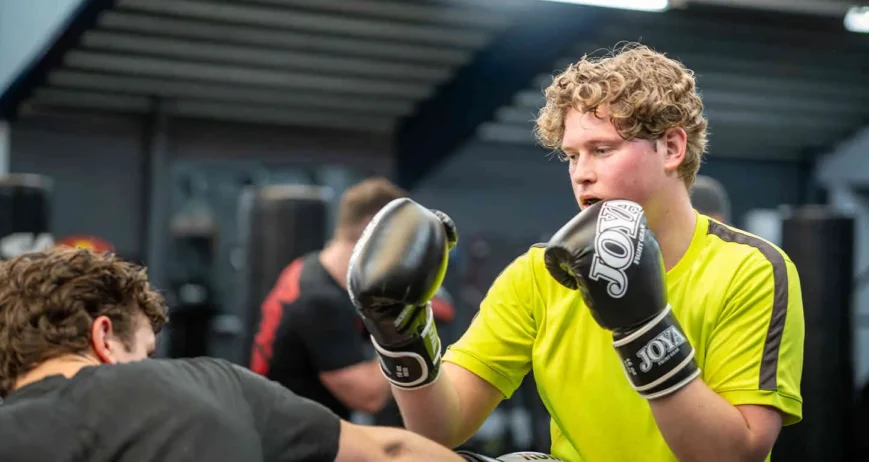 Sporter traint op de bokszak tijdens de boksles bij BOKS Leiden